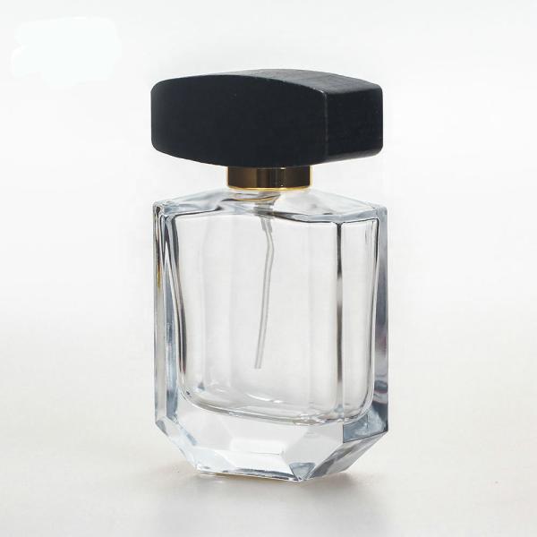 Empty glass perfume bottle with cap and pump spray collarwith wooden black cap