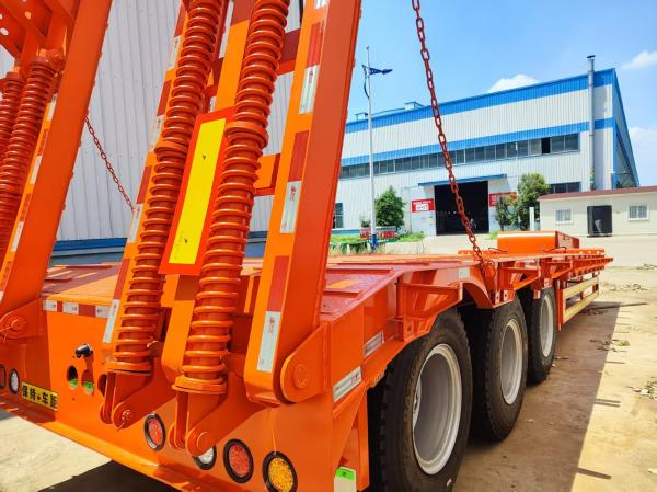 Orange 3-Axle Lowboy Semi-Trailer: 60T Payload, Sturdy Design for Heavy Loads