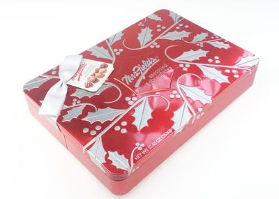 La couleur rouge gravent la caisse en refief de bidon en métal de chocolat avec l'arc et le chèque-cadeau de ruban