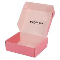 O encarregado do envio da correspondência pequeno do presente do cartão reciclável cor-de-rosa encaixota a caixa de papel ondulada de dobramento