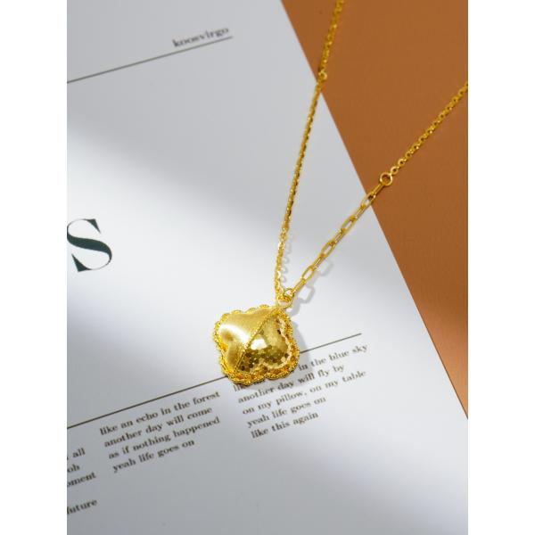 Un pendentif de trèfle à quatre feuilles, des bijoux en or de 24 carats.
