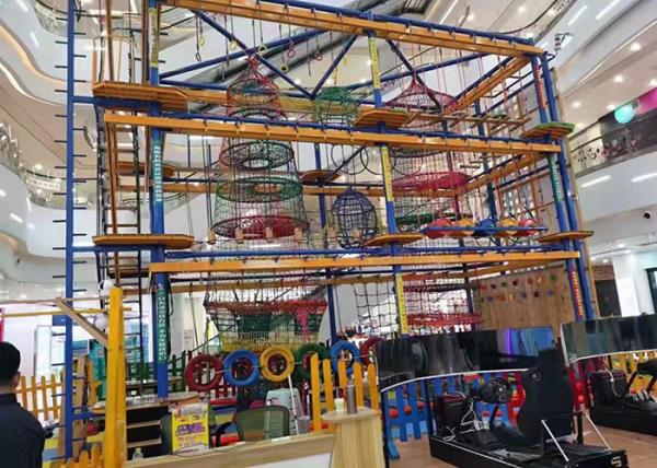 As cordas internas de escalada coloridas da parede percorrem a aventura para crianças dos adultos