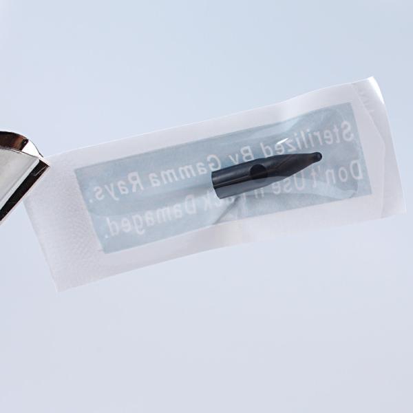 A agulha preta dos acessórios descartáveis da tatuagem derruba para a luz do sol/máquina dourada de Rosa