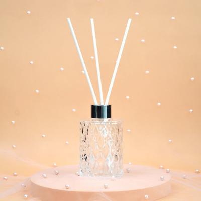 Des bouteilles de diffuseur noir mat rond et vide de luxe avec un bouchon et des bâtons en or