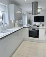 O armário de cozinha modular moderno L branco dá forma ao projeto da cozinha com parte superior de pedra de quartzo