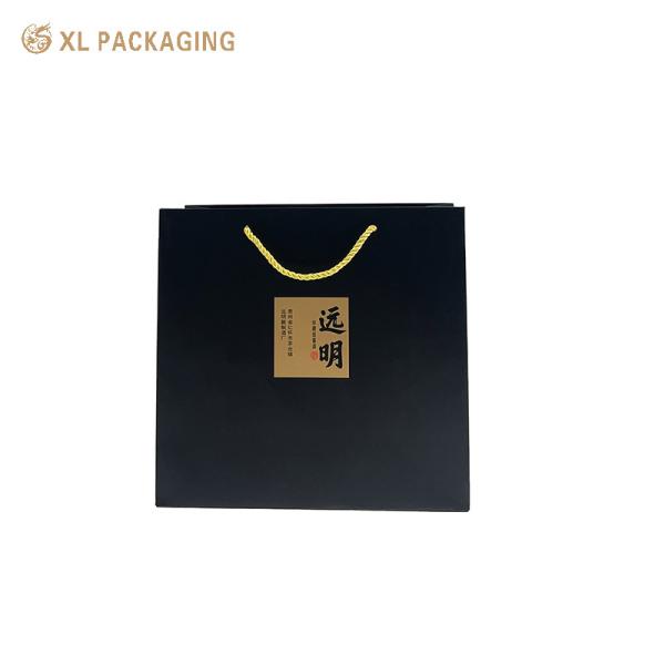 Custom Logo Matte Black Paper Tote Bag with Kraft Calligraphy Stickers and Twisted Golden Cord Handles for Eco-Friendly Gift Packaging