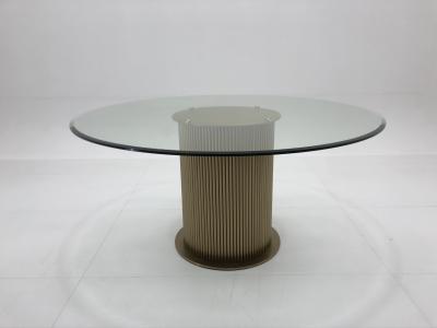 Une table ronde en verre pour 6 personnes, une table à manger en acier inoxydable.