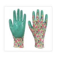 Las pequeñas manos ponen verde el nitrilo que sumerge guantes que cultivan un huerto protectores