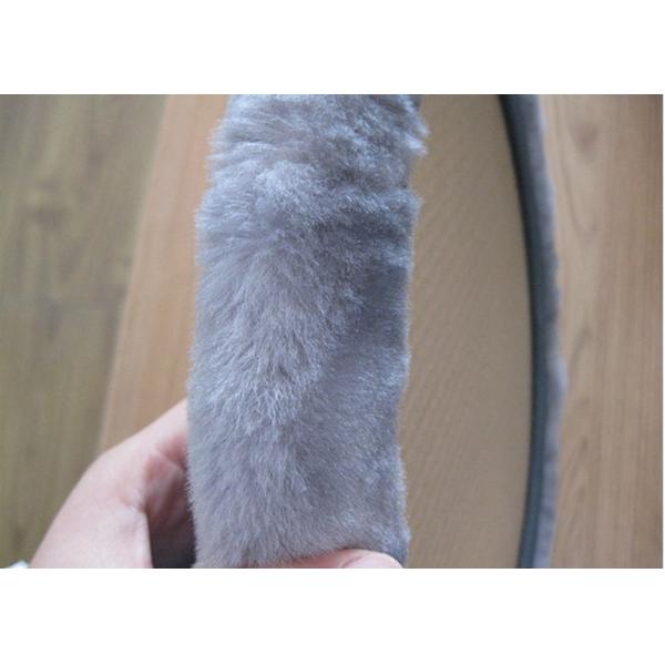 Mano negra teñida de la cubierta del volante de la zalea que cose para la decoración del coche