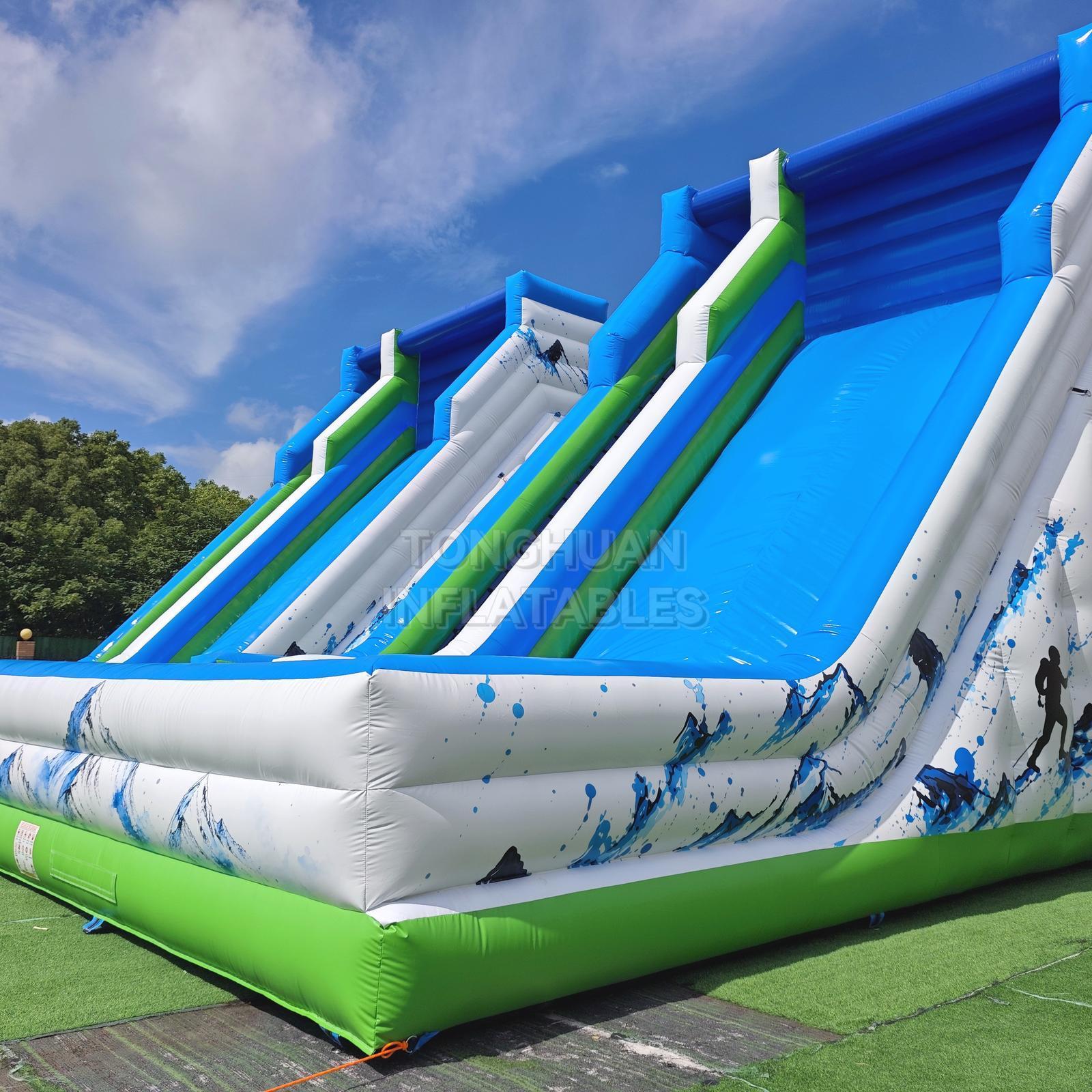 Commercial K2 Double Lane Inflatable Slide with Mountain Graphics High Side Walls and Safety Landing Areas for Parks Events and Rentals