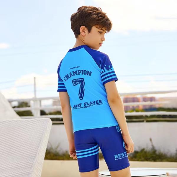 El traje de baño de los niños de entonado de colores del traje de baño partido del muchacho azul