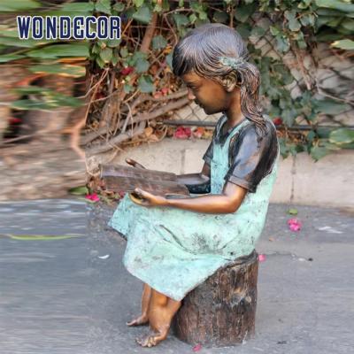 Vida feita sob encomenda - tamanho uma estátua de bronze de uma leitura da menina em um coto de árvore