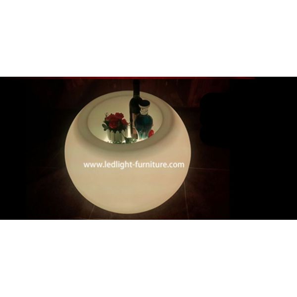 A bola dada forma conduzida ilumina acima a mesa de centro com cubeta de gelo e suporte de garrafa do vinho