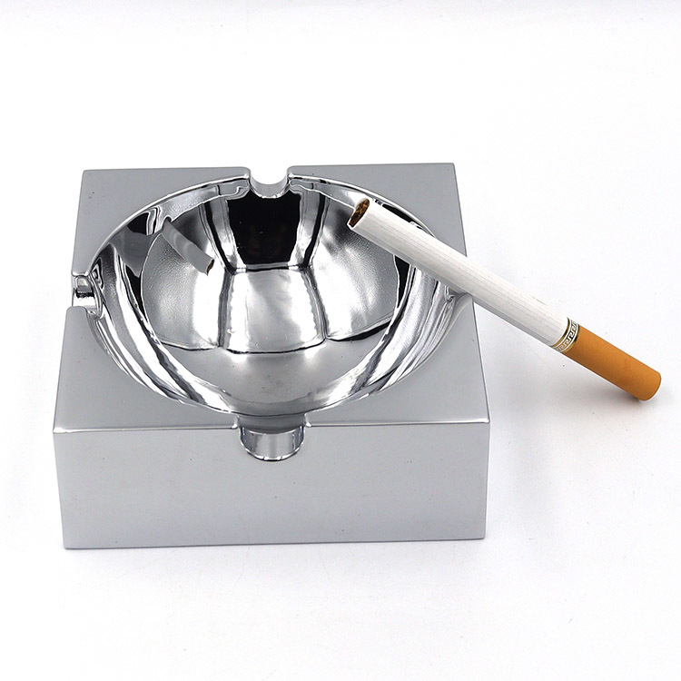 Square polished metal ashtray with glossy mirror surface and multiple notches for stable placement