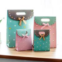 Le métier de boutique a coloré les sacs de papier de cadeau avec le ruban auto-adhésif