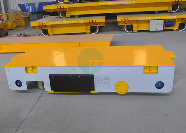 Battery operated steerable motorized trackless transfer car on cement floor