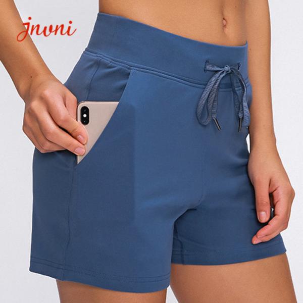 Os esportes das senhoras afrouxam o short do Gym com o short seco rápido da ioga do exercício dos bolsos