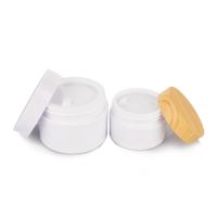 Bouteille de crème en plastique cylindrique de 120 ml avec couvercle en bambou et corps blanc opaque
