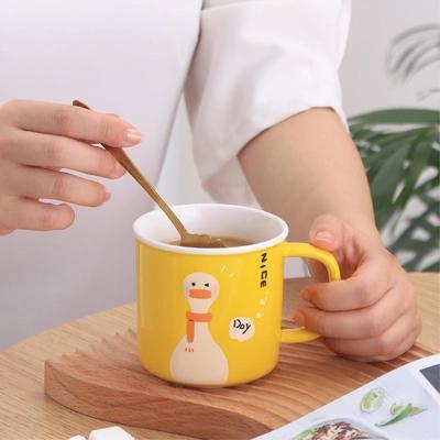 Une tasse en céramique à canard jaune avec base de chauffage USB