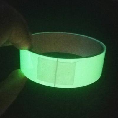 Fulgor no sinal luminescente luminoso da saída de emergência da fita escura do vinil