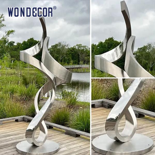 Gran escultura de acero inoxidable en forma de metal forjado y retorcido en el parque