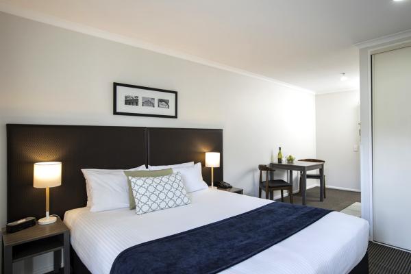 Budget hotels interior design of Leather upholstery headboard bed with Wood structure desk and tables