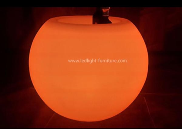 A bola dada forma conduzida ilumina acima a mesa de centro com cubeta de gelo e suporte de garrafa do vinho