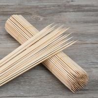 O espeto de bambu redondo deu laços em varas para o alimento e a grade do ASSADO