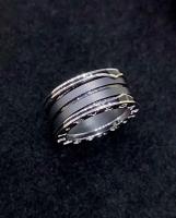 Une bague en or de luxe de 18 carats avec deux boucles en or blanc de 18 carats et une spirale en céramique noire.