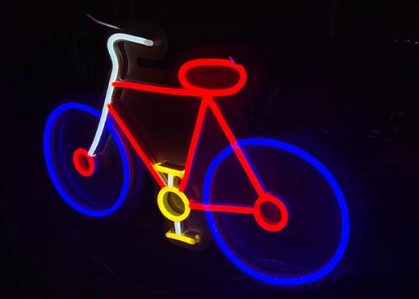 Las ligeras señales llevadas por encargo de Vasten montan en bicicleta la cartelera de la señal de neón