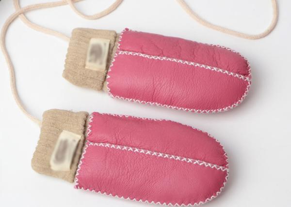 A mão a mais morna mitenes costurados da pele de carneiro do bebê com luz - punho cor-de-rosa