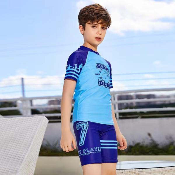 El traje de baño de los niños de entonado de colores del traje de baño partido del muchacho azul