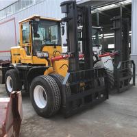 O caminhão de empilhadeira industrial amarelo 6000kg articulou o terreno áspero da empilhadeira