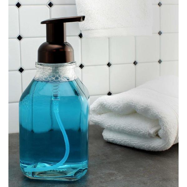 Прозрачный стеклянный пустой насос пены разливает прочную ровную поверхность по бутылкам