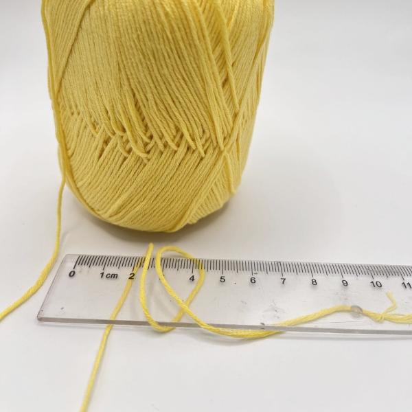 Le bébé main-bras tricotent le fil a mercerisé des fils de coton font du crochet le coton 100%