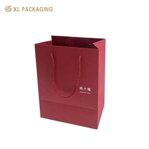 Luxury Wine Red Paper Gift Bag with Custom Logo, Reinforced Folded Bottom, and Twisted Paper Handles for Premium Shopping and Gift Packaging