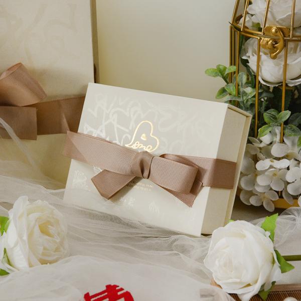 La boîte de mariage de luxe est équipée d'un emballage de cadeau élégant en crème rouge, un ruban satiné, un arc en or.