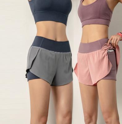 As mulheres da aptidão da ioga do exercício ostentam o short do montante do Gym com bolso interno