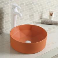 Évier rond en céramique lisse de salle de bains au-dessus de contre- lavabo orange de dessus de Tableau