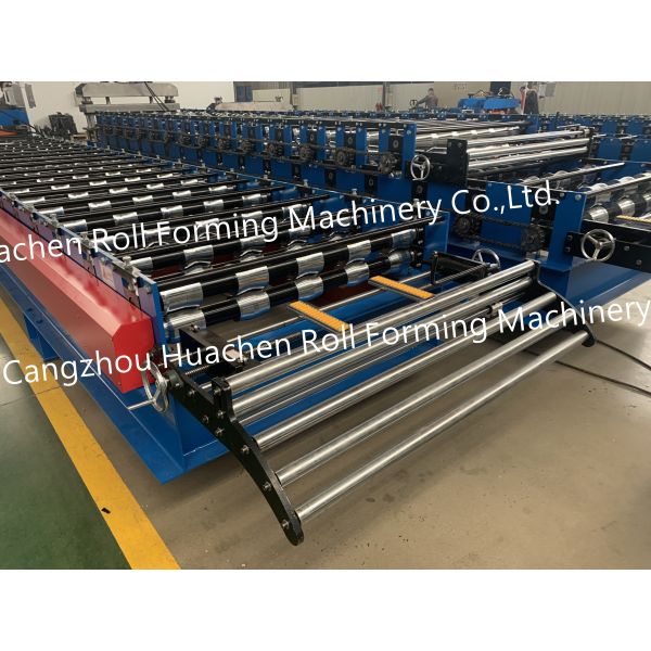 A metal roof panel manufacturing machine for producing tile-shaped corrugated roof panels by rolling process