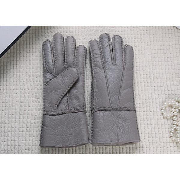 Los guantes más calientes grises alineados piel real de la zalea alisan la superficie con el finger