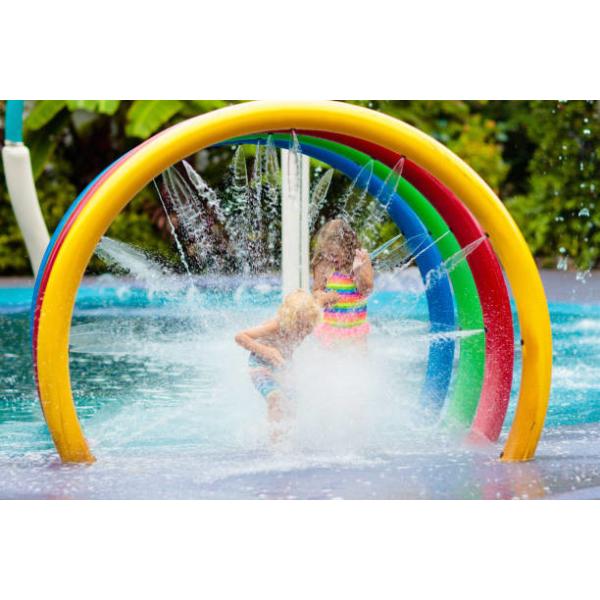 Los niños del círculo del arco iris del parque del espray de agua riegan el parque colorido del chapoteo del agua del patio