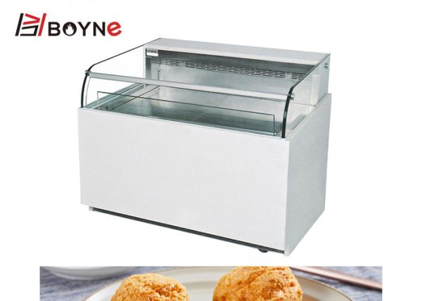 Um único refrigerador aberto lado da exposição do bolo de camada para o restaurante