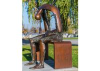 Vida - homem de bronze de moldação do tamanho que senta-se na estátua do banco