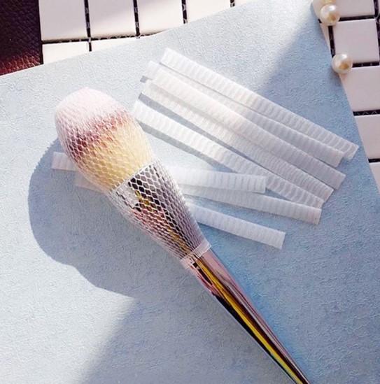 A composição escova redes de empacotamento do cosmético da tampa protetora das luvas da malha