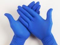 As luvas médicas descartáveis do exame do nitrilo da cor azul pulverizam livre