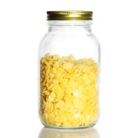 Un pot de thé en verre rond avec un couvercle en or