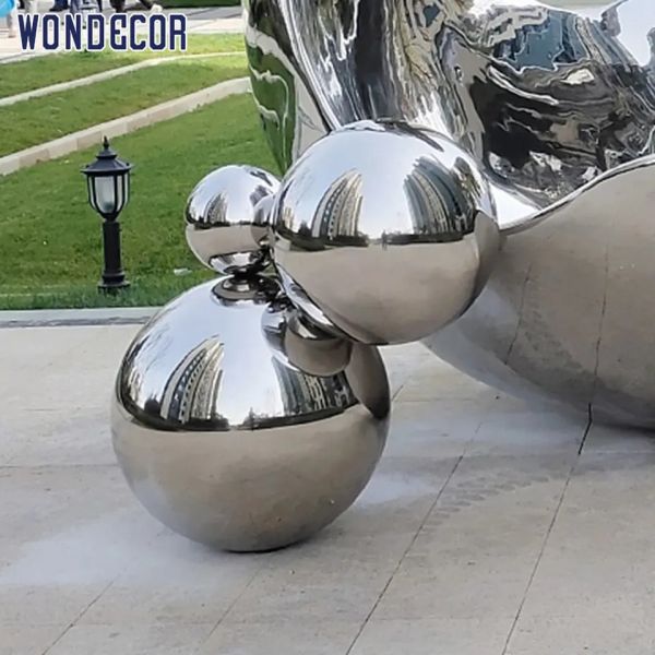 Большое зеркало открытого сада отполировало выкованную сферу скульптуры металла неубедительную
