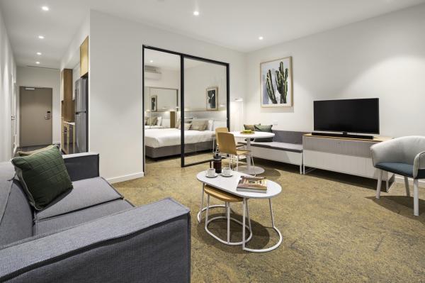 Fabric upholstered bed headboard and sofa chairs for hotel style apartment with Laminate board desk and cabinets