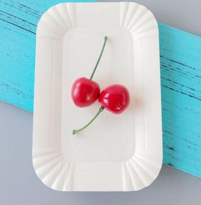 O bolo de aniversário descartável dos utensílios de mesa ata a placa de papel retangular